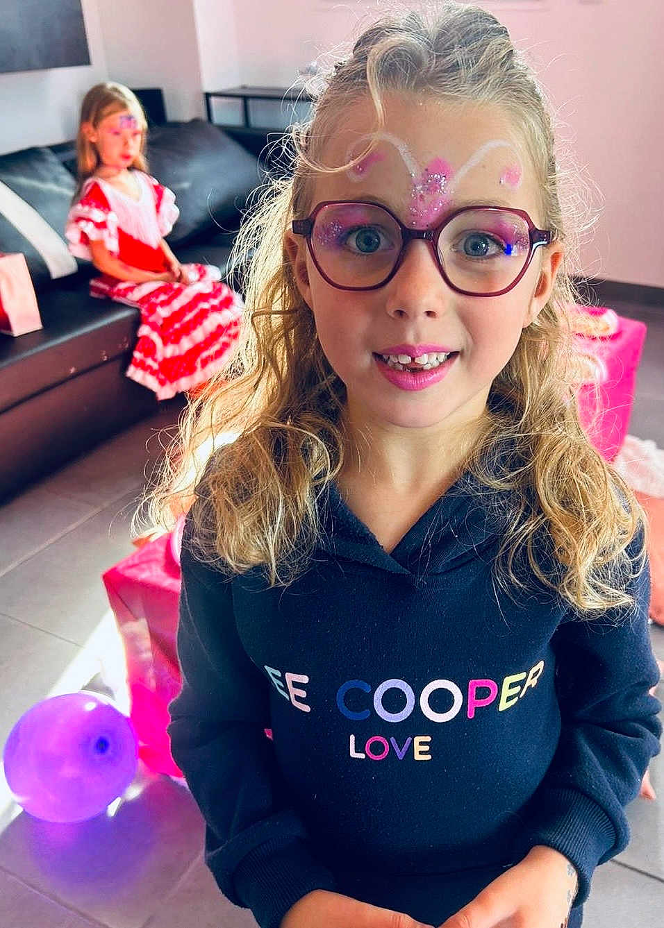Alice participe au concours pour gagner de l'argent avec cette photo : accessories, blonde, child, couch, face, female, furniture, girl, glasses, hair, happy, head, indoors, people, person, photobombing, photography, portrait, purple, smile