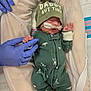 newborn, baby, infant, hospital, medical_tube, nasal_cannula, hat, green_hat, onesie, sleeper, gloved_hand, medical_gloves, bassinet, hospital_bedding, blanket, tiny, premature_baby, neonatal, healthcare, patient