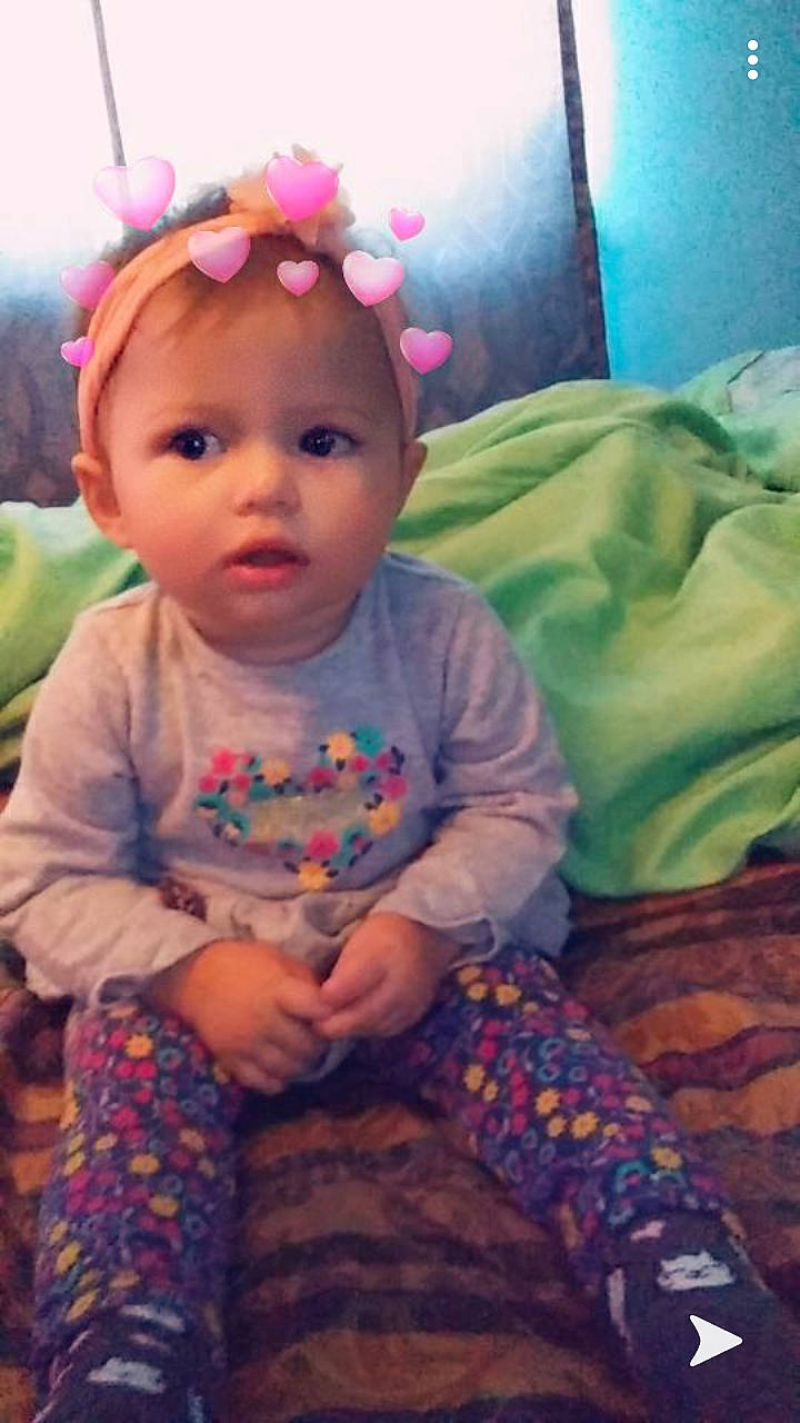 Arabella is registered to the contest to win money with this photo: baby, baby_products, baby_toddler_clothing, cheek, child, eye, face, hair_accessory, head, iris, nose, person, pink, play, sitting, skin, smile, toddler