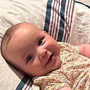 Anya joined the competition — help win amazing prizes! baby, smiling, infant, towel, striped_towel, floral_outfit, cute, lying_down, happy, face, skin, child, indoors, person, young_child, cheeks, eyes, clothing, soft_texture, comfort