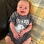 Beau is registered to the contest to win money with this photo: baby, infant, smile, onesie, nirvana, clothing, couch, pillow, yellow, checkered, blanket, happy, person, skin, head, hands, legs, sitting, indoors, cute