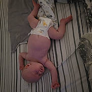 Anna participe au concours pour gagner de l'argent avec cette photo : baby, sleeping, bed, blanket, diaper, striped_bedspread, infant, skin, arm, leg, head, peaceful, cozy, rest, indoors, person, newborn, soft, comfort, nap