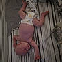 baby, sleeping, bed, blanket, diaper, striped_bedspread, infant, skin, arm, leg, head, peaceful, cozy, rest, indoors, person, newborn, soft, comfort, nap