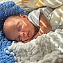 Eli is registered to the contest to win money with this photo: baby, sleeping, newborn, blanket, knitted, blue, white, soft_light, face, arm, peaceful, cozy, infant, resting, portrait, closeup, indoor, cute, child, toddler