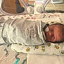 newborn, baby, hospital, incubator, nasal_tube, sleeping, swaddled, grey_clothing, pillow, animal_pattern, footprints, medical, infant, bed, cute, peaceful, wrapped, healthcare, premature, crib