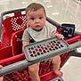 baby, shopping_cart, child, store, aisle, floor, wallet, hand, foot, clothing, safety_bar, red, gray, curious, indoor, person, seat, plastic, shopping, retail