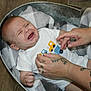 Braxton joined the competition — help win amazing prizes! baby, crying, infant, blanket, metal_tub, tattoos, hands, white_shirt, vehicles, floor, wood_flooring, indoor, child, person, clothing, expression, emotion, comfort, care, portrait