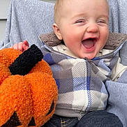 Blaine is registered to the contest to win money with this photo: baby, child, smiling, laughing, plaid_jacket, pumpkin, toy, fall, halloween, cozy, cute, happy, infant, outdoor, clothing, person, seat, fabric, head, portrait