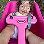 baby, child, toddler, swing, pink, outdoor, grass, curly_hair, smiling, happy, play, seat, toy, strap, person, face, legs, hands, daylight, nature