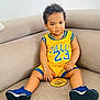 Mateus a rejoint le concours — aidez-le/la à gagner de superbes lots ! bracelet, casual, child, comfortable, couch, curly_hair, expression, home, indoor, person, portrait, relaxed, sitting, sneakers, sole_of_shoes, sportswear, toddler, wooden_sign, yellow_clothing, young_child