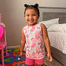 Nayeli joined the competition — help win amazing prizes! child, girl, smiling, indoor, bedroom, colorful_mat, toy, shorts, tank_top, hair_buns, carpet, bed, pillow, furniture, play, happy, person, cute, childhood, home