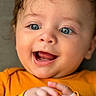 baby, child, blue_eyes, smiling, happy, close_up, orange_clothing, hands, face, infant, cute, portrait, expression, skin, eyelashes, mouth, tongue, cheeks, hair, soft_background