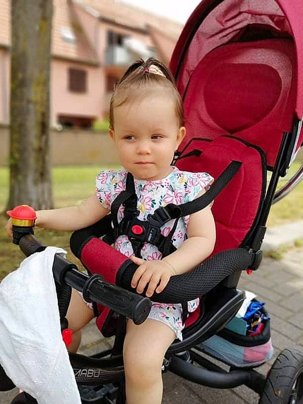 Kimberly a rejoint le concours — aidez-le/la à gagner de superbes lots ! baby, baby_carriage, baby_products, baby_toddler_clothing, child, comfort, event, fun, happy, lap, leisure, magenta, person, pink, recreation, sitting, thigh, tire, toddler, wheel