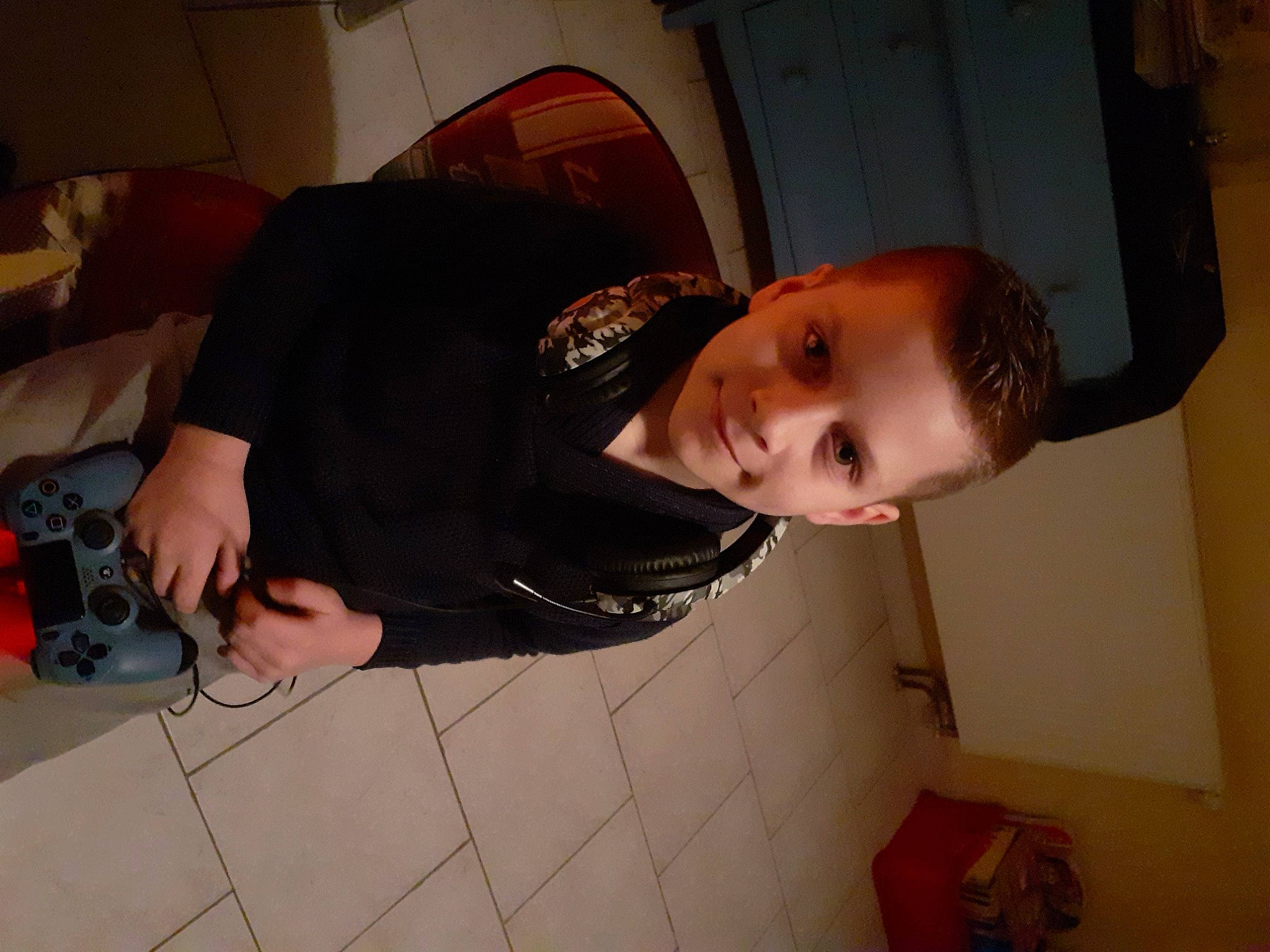 Ylan a rejoint le concours — aidez-le/la à gagner de superbes lots ! camera, child, comfort, elbow, eyewear, flooring, fun, hat, joy, mouth, nose, person, room, sitting, wood