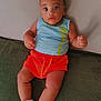Layhann a rejoint le concours — aidez-le/la à gagner de superbes lots ! baby, child, infant, blue_eyes, striped_tank_top, orange_shorts, socks, cartoon_socks, couch, green_couch, indoor, relaxed, looking_at_camera, cute, small_hands, legs, face, person, seated, comfortable