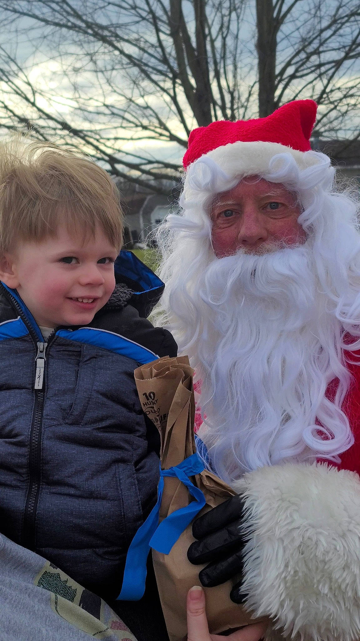 Mason is registered to the contest to win money with this photo: beard, christmas, event, eye, face, facial_expression, facial_hair, fun, fur, hair, happy, head, headwear, holiday, human_body, joy, moustache, person, santa_claus, smile