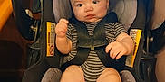 Easton is registered to the contest to win money with this photo: baby, black_car_seat, car_seat, child, cute, expression, face, gray_padding, hands, indoors, infant, person, safety_harness, seatbelt, sitting, small_feet, striped_clothing, toddler, wood_paneling, young_child