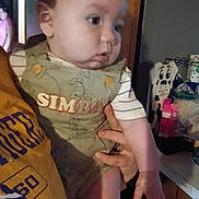 Easton is registered to the contest to win money with this photo: arm, baby, casual, child, clothing, curious, decor, dog_art, face, furniture, hand, holding, home, indoor, infant, kitchen, person, portrait, sleeve, young_child