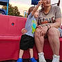 Levi joined the competition — help win amazing prizes! child, toddler, woman, playground, slide, red_bench, blue_shoes, casual_clothing, outdoor, daylight, pointing, shorts, sneakers, trees, sky, smiling, person, family, park, fun