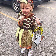 Izabella is registered to the contest to win money with this photo: child, girl, costume, halloween, giraffe, lollipop, parking_lot, car, bag, ghost, sparkle, dress, headband, shoes, smile, outdoor, fun, celebration, holiday, cute