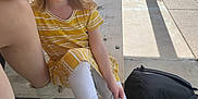 Izabella is registered to the contest to win money with this photo: child, girl, smile, yellow_dress, white_leggings, sneakers, snack, bench, outdoor, playground, backpack, sunlight, person, happy, wood, park, casual, holding, sitting, daytime