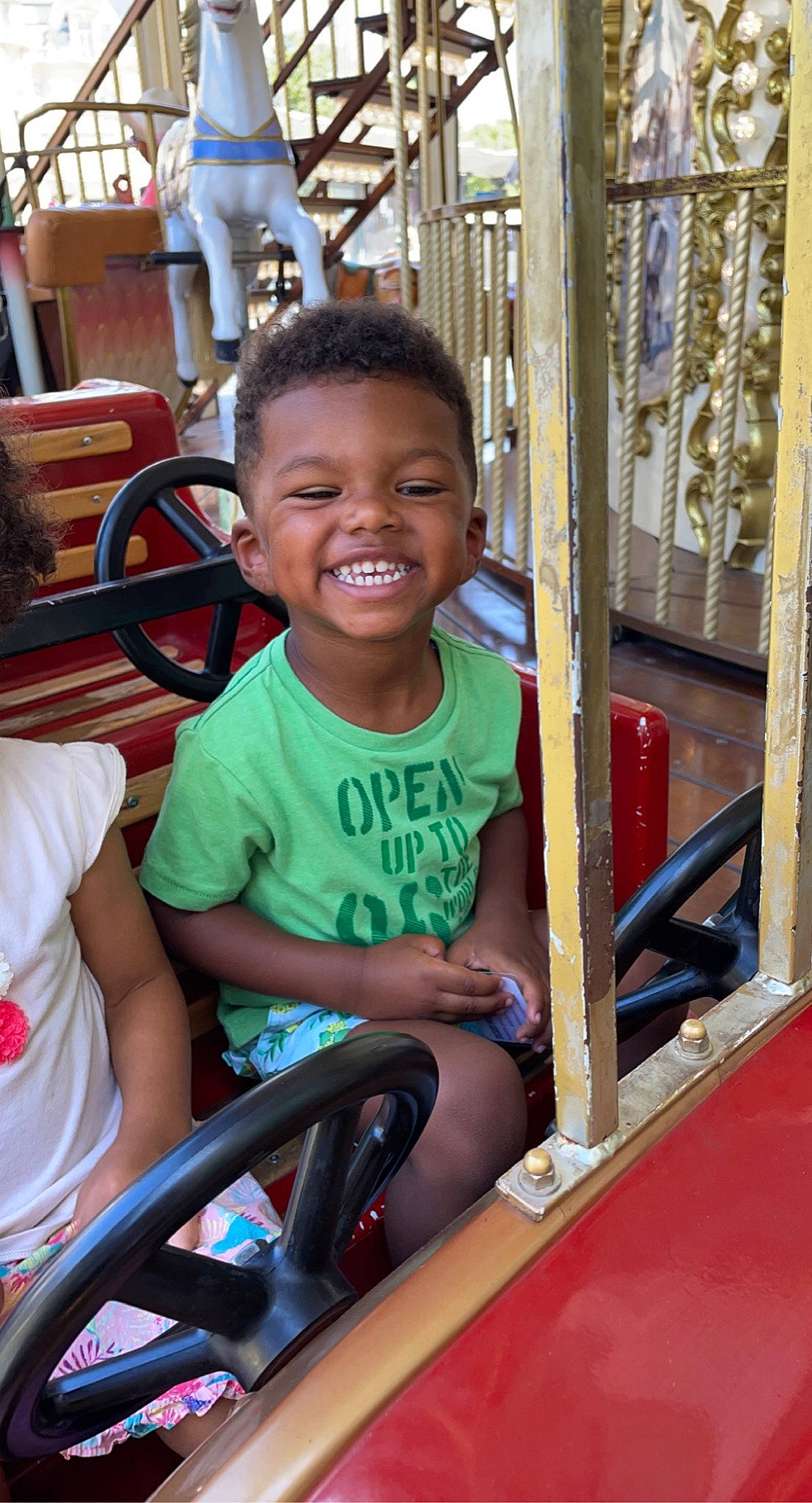 Issa participe au concours pour gagner de l'argent avec cette photo : auto_part, automotive_exterior, automotive_tire, automotive_wheel_system, chair, facial_expression, fun, happy, joy, leisure, motor_vehicle, person, recreation, skin, smile, steering_wheel, toddler, vehicle, vehicle_door, wheel