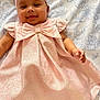 Amelia is registered to the contest to win money with this photo: baby, infant, smiling, pink_dress, headband, bow, socks, floral_bedspread, lying_down, cute, happy, child, portrait, indoors, baby_fashion, soft_lighting, adorable, playful, happy_face, closeup