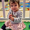 Nova joined the competition — help win amazing prizes! toddler, child, smiling, indoor, playmat, toy, sitting, cute, girl, sweater, skirt, colorful, floor, young_child, playtime, happy, person, long_sleeve, casual_clothing, expression