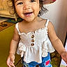 carpet, casual_clothing, child, cute, denim_shorts, footwear, hair, happy, home, indoor, living_room, patchwork, person, playful, portrait, smiling, standing, toddler, white_top, young_child