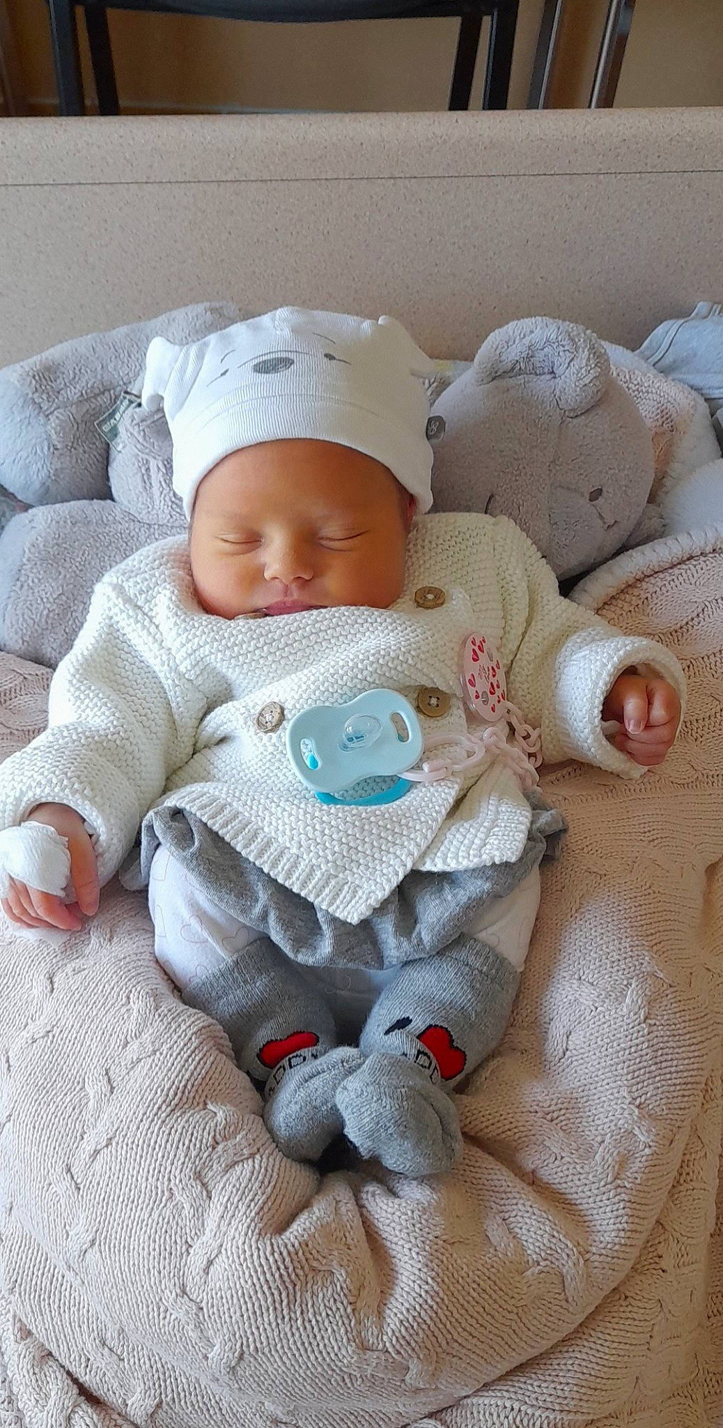 élya a rejoint le concours — aidez-le/la à gagner de superbes lots ! baby, baby_products, baby_safety, baby_sleeping, baby_toddler_clothing, beanie, cheek, child, comfort, eye, headgear, knit_cap, knitting, linens, person, room, sitting, skin, sleeve, toddler