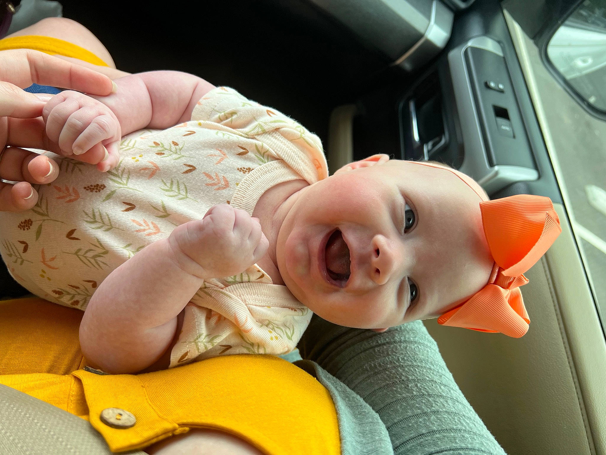 Lily is registered to the contest to win money with this photo: baby, baby_toddler_clothing, child, comfort, facial_expression, finger, gesture, hand, happy, headwear, mammal, mouth, nose, orange, person, product, skin, smile, thumb, toddler