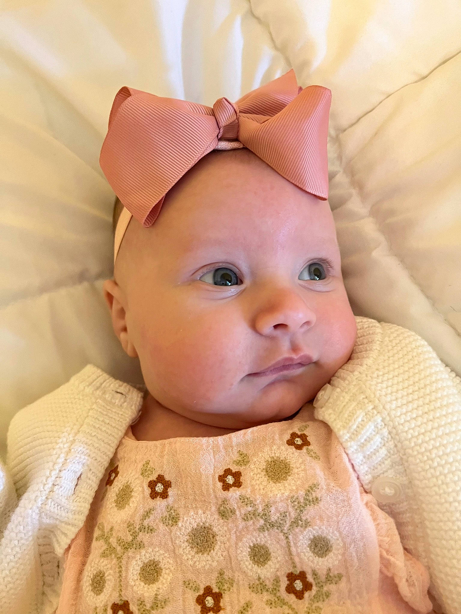 Lily is registered to the contest to win money with this photo: baby, baby_toddler_clothing, cheek, child, chin, comfort, eyebrow, eyelash, face, hair_accessory, headgear, iris, linens, lip, nose, peach, person, pink, skin, sleeve