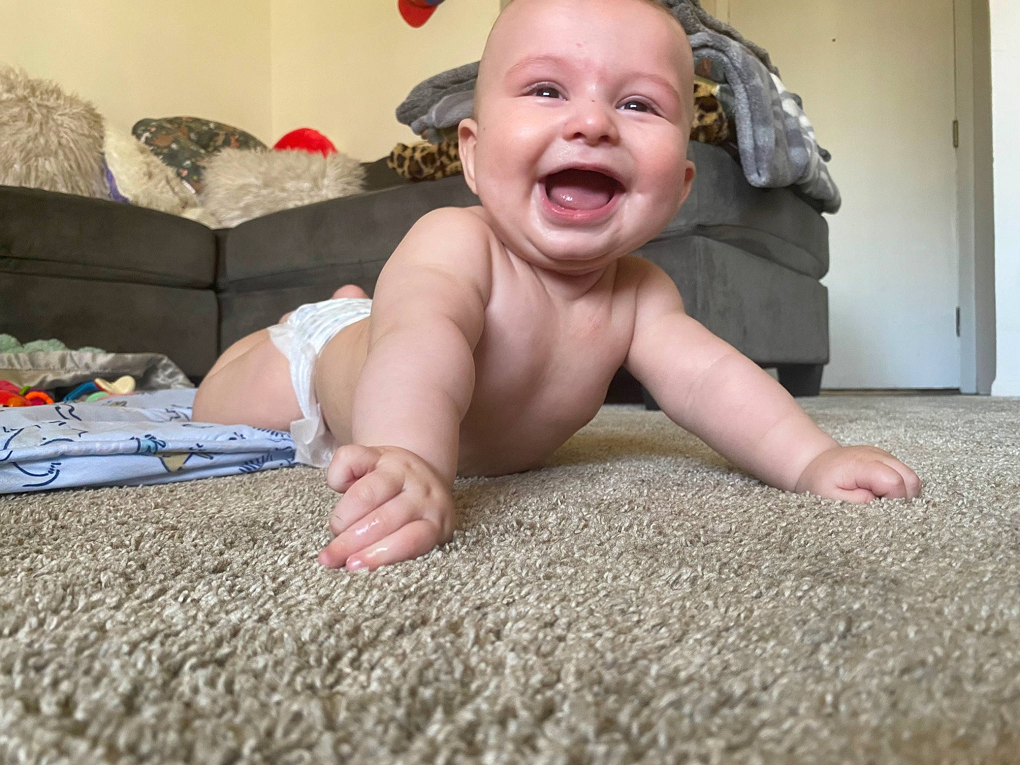 Rylan is registered to the contest to win money with this photo: baby, baby_laughing, baby_toddler_clothing, cheek, child, comfort, crawling, finger, floor, flooring, fun, happy, linens, mouth, nose, person, sitting, skin, smile, toddler