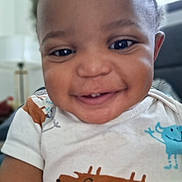 Gregory joined the competition — help win amazing prizes! baby, smiling, face, child, onesie, clothing, indoor, cute, happy, portrait, infant, closeup, person, toddler, expression, apparel, animal_print, cheerful, skin, young