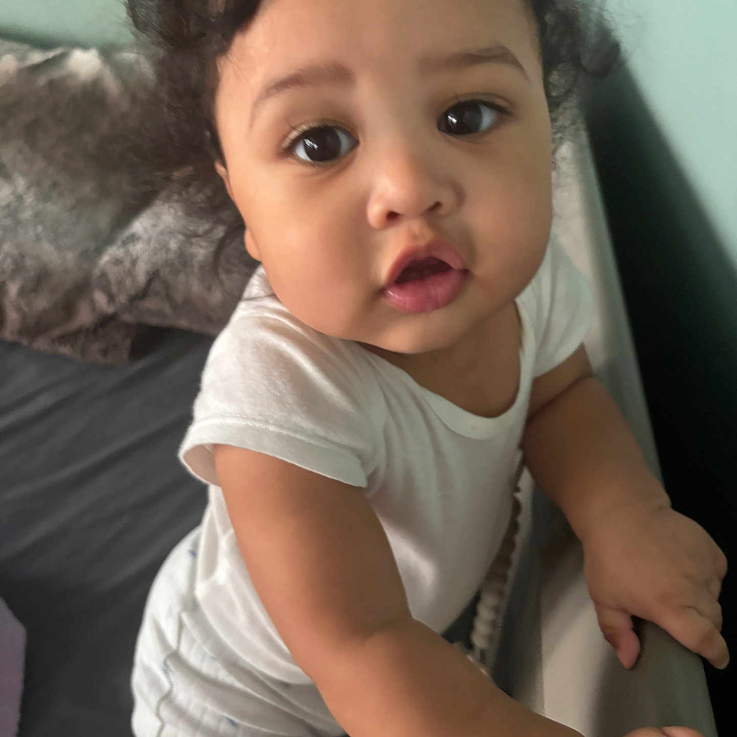 Artis joined the competition — help win amazing prizes! baby, bed, child, close_up, curiosity, curly_hair, cute, expression, face, hands, indoor, infant, person, pillow, portrait, skin, sleepwear, toddler, white_clothing, young_child