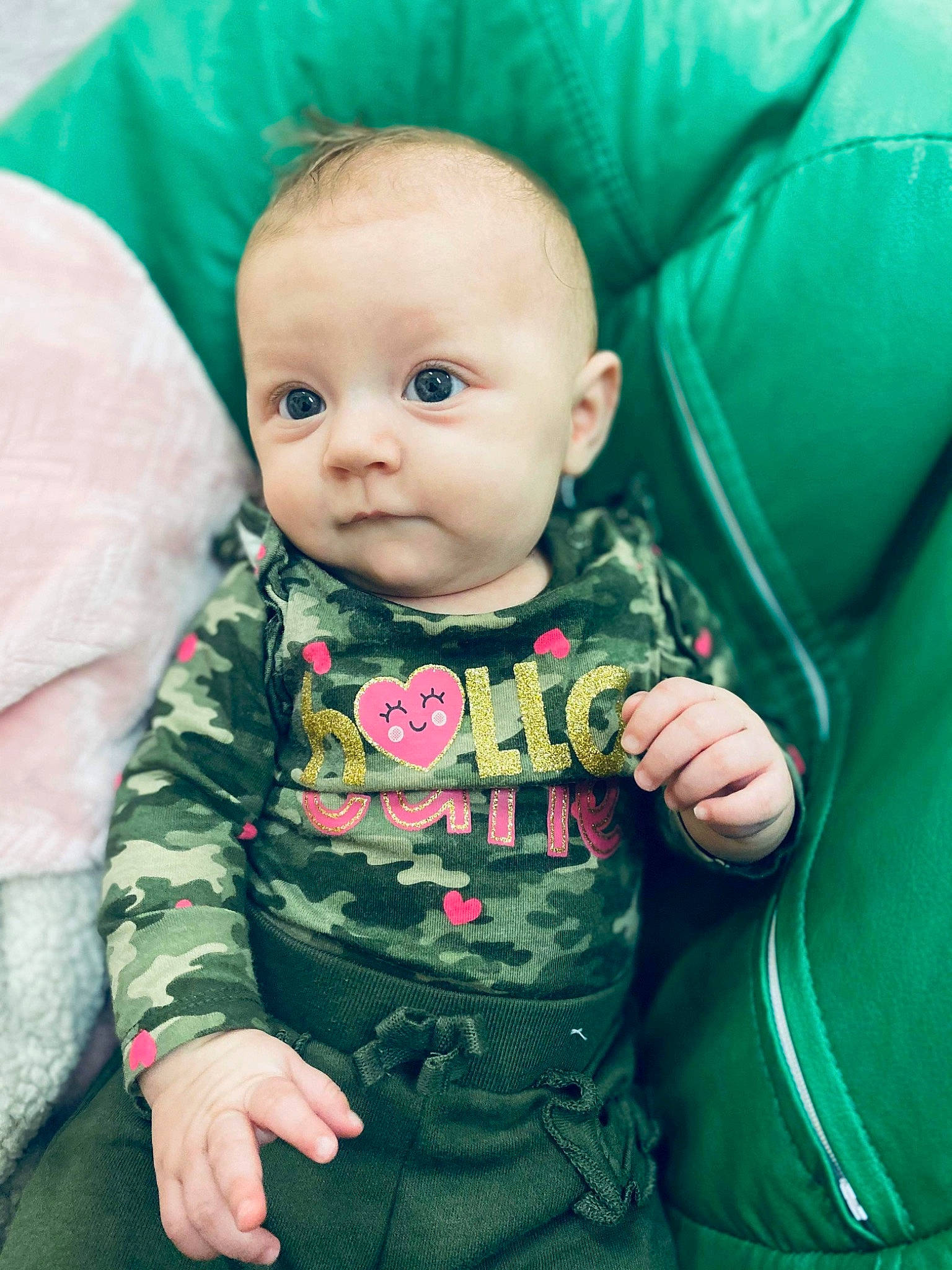 Laila is registered to the contest to win money with this photo: baby, baby_toddler_clothing, cheek, chin, clothing, comfort, eye, facial_expression, green, happy, human_body, iris, lip, mouth, nose, outerwear, person, pink, product, skin