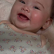 Mariko is registered to the contest to win money with this photo: baby, infant, smile, happy, face, cheeks, clothing, onesie, floral_pattern, soft_texture, lying_down, cute, child, skin, head, hair, mouth, tongue, eyes, expression