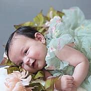 Kylah-Moon Hwangbo is registered to the contest to win money with this photo: baby, infant, smile, face, dress, embroidery, green_dress, flowers, leaves, soft_texture, fluffy_surface, cute, happy, child, portrait, lying_down, dimples, skin, hand, closeup