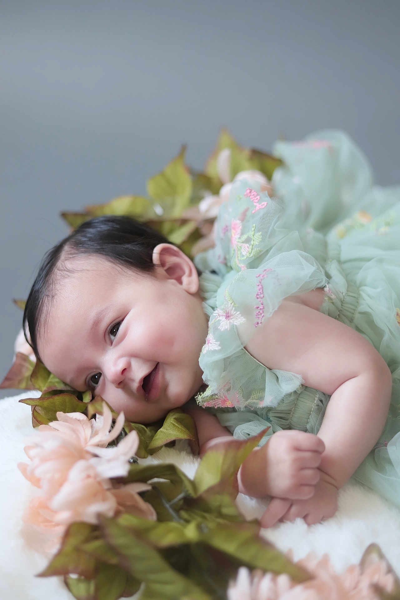 Kylah-Moon Hwangbo is registered to the contest to win money with this photo: baby, infant, smile, face, dress, embroidery, green_dress, flowers, leaves, soft_texture, fluffy_surface, cute, happy, child, portrait, lying_down, dimples, skin, hand, closeup