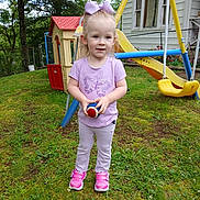 Roe joined the competition — help win amazing prizes! toddler, child, girl, outdoor, playground, grass, ball, playhouse, swing, shoes, purple_shirt, bow, smile, person, daylight, house, window, tree, greenery, pants
