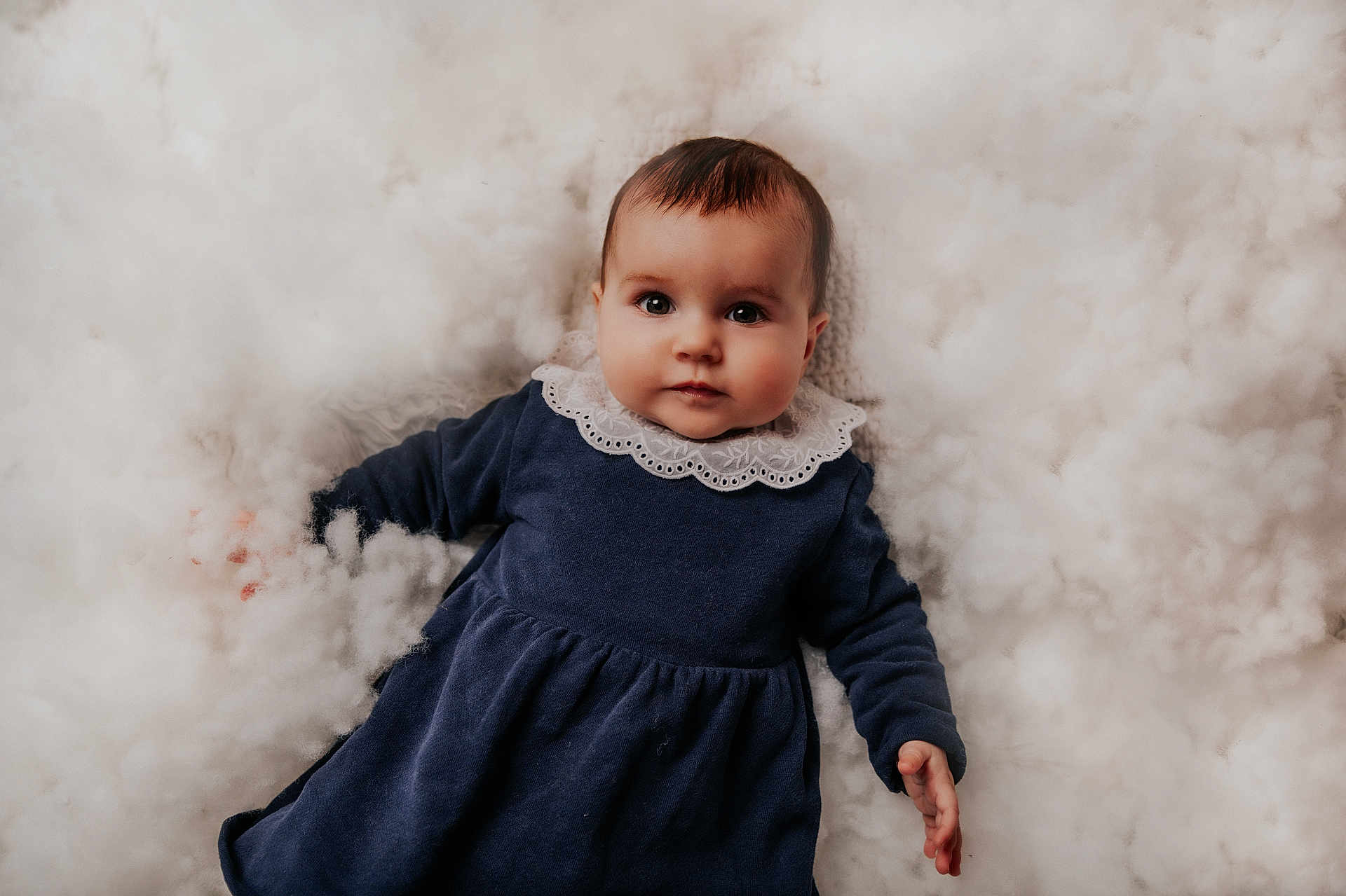 Emy a rejoint le concours — aidez-le/la à gagner de superbes lots ! baby, infant, child, portrait, face, eyes, clothing, dress, lace_collar, hand, soft, fluffy, background, lying_down, cute, innocent, looking_at_camera, indoors, warm_tones, skin