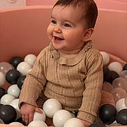 Emy participe au concours pour gagner de l'argent avec cette photo : baby, child, smile, happy, ball_pit, balls, pink, beige, sweater, knitted, indoor, playtime, cute, infant, portrait, person, young_child, fun, colorful, seated