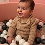 baby, child, smile, happy, ball_pit, balls, pink, beige, sweater, knitted, indoor, playtime, cute, infant, portrait, person, young_child, fun, colorful, seated