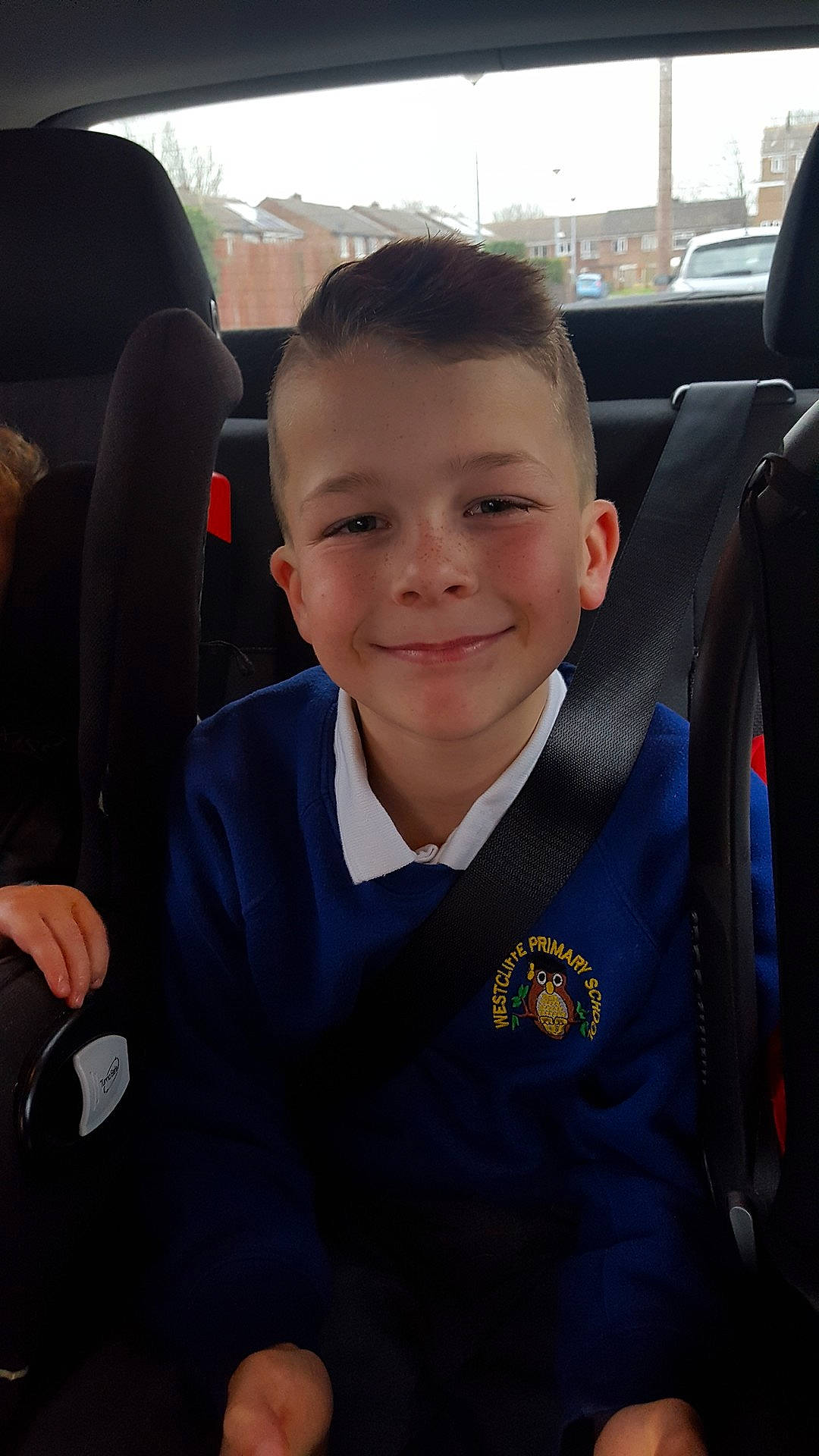 Clayton is registered to the contest to win money with this photo: boy, car, car_seat, child, cool, day, driving, eye, facial_expression, family_car, fun, girl, joy, person, product, sedan, sitting, smile, standing, toddler