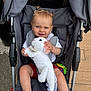 baby, child, cute, expression, footwear, happy, outdoor, person, pigtails, playful, plush_toy, seatbelt, shirt, shorts, sidewalk, stroller, summer_clothing, toddler, toy, white_toy
