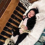 Annabelle joined the competition — help win amazing prizes! baby, black_clothing, blanket, brick_wall, cat_costume, child, costume, cute, decoration, face, indoor, infant, person, pink_clothing, plush, skeleton_hand, skull, smiling, spooky, wooden_bench