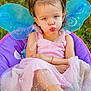 child, girl, fairy_wings, pink_dress, sparkles, pigtails, chair, outdoor, grass, footwear, bracelet, pouty_face, cute, portrait, costume, summer, playful, fashion, young, person