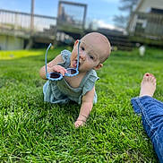 Rori joined the competition — help win amazing prizes! baby, child, grass, outdoor, sunglasses, blue_sky, jeans, foot, crawling, green, person, playful, summer, lawn, casual, sunny, daylight, cute, tongue_out, relaxed