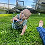 baby, child, grass, outdoor, sunglasses, blue_sky, jeans, foot, crawling, green, person, playful, summer, lawn, casual, sunny, daylight, cute, tongue_out, relaxed
