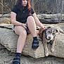 Hoss is registered to the contest to win money with this photo: person, dog, pitbull, rock, outdoor, trees, forest, sitting, pet, leash, shorts, sandals, socks, bracelet, expressionless, natural_light, portrait, ground, boulder, woodland